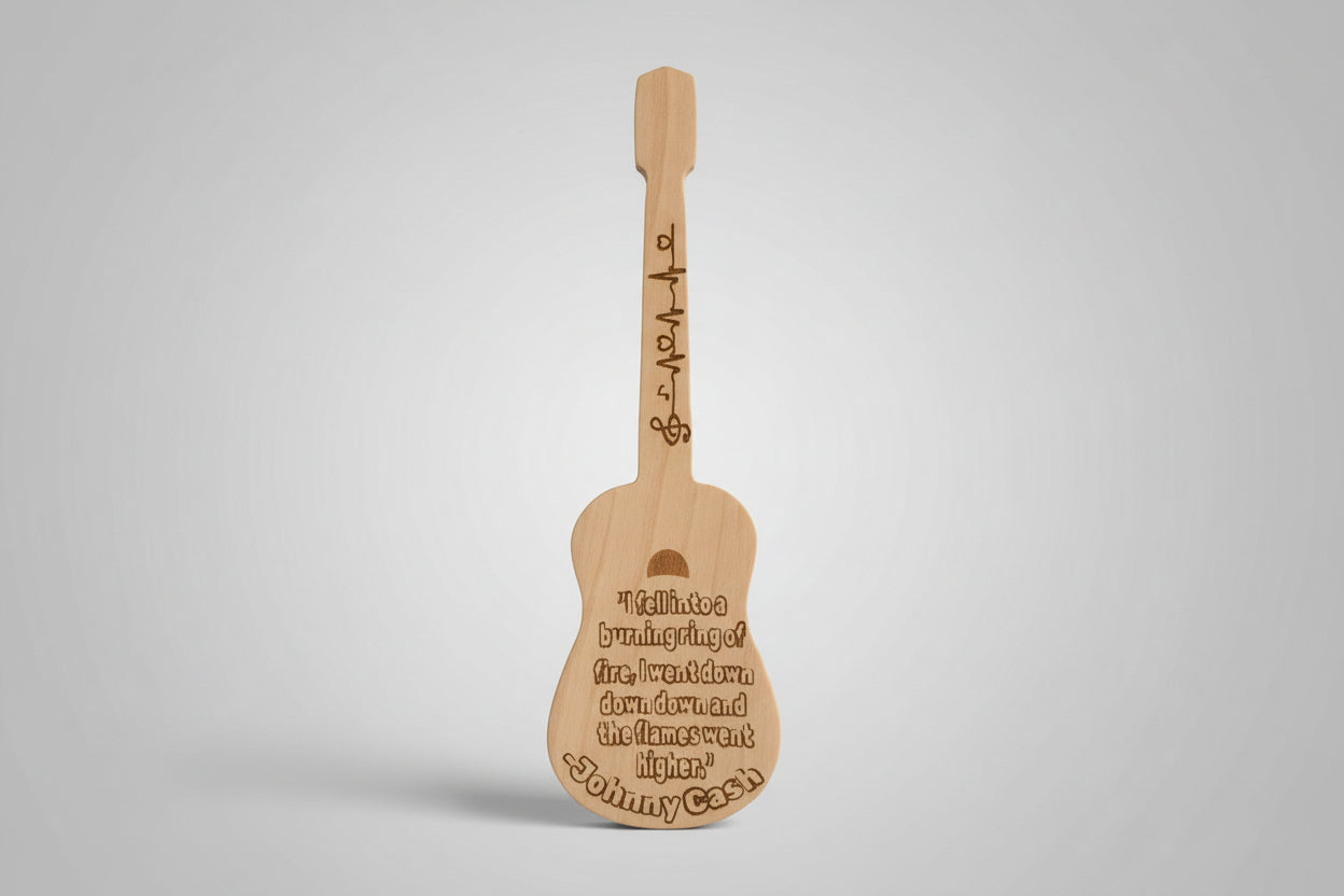 Wooden guitar-shaped paddle with engraved text on a wooden surface