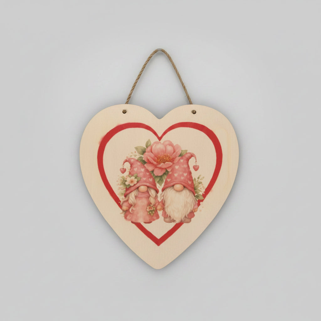 Heart-shaped wooden plaque with two gnomes and a flower on a textured wall background