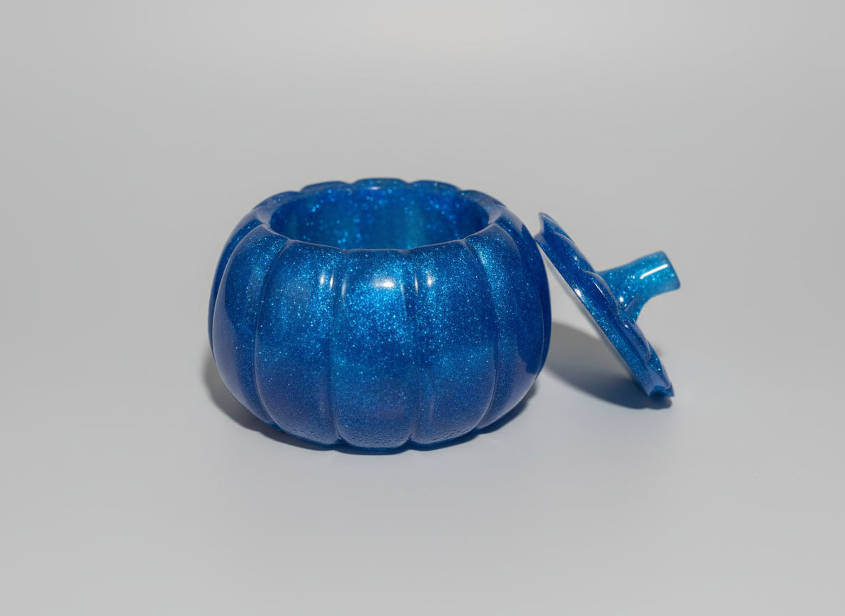 Blue glittery pumpkin-shaped container with a lid.