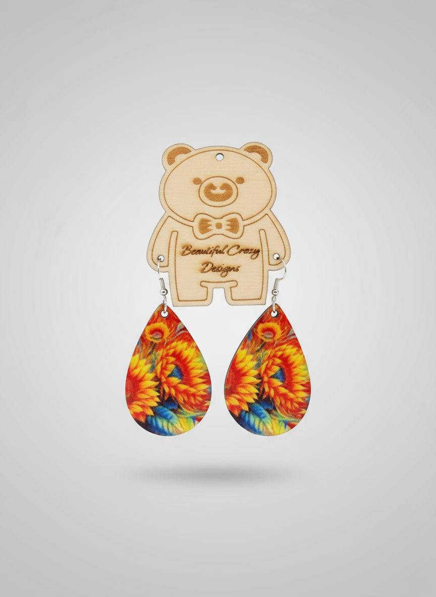 Colorful sunflower teardrop-shaped earrings with a wooden bear-shaped holder on a light gray background.