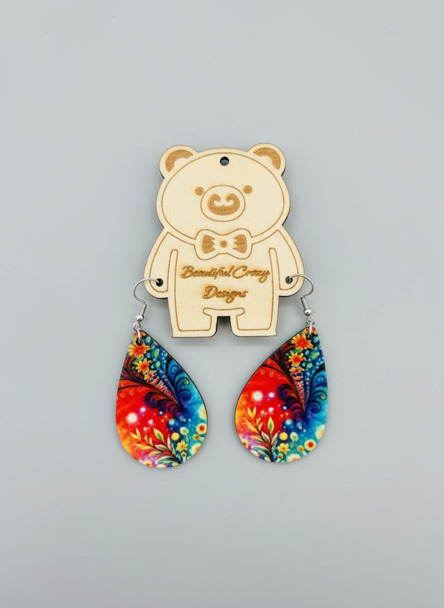 Colorful wildflower teardrop earrings with a bear-shaped pendant on a gray background