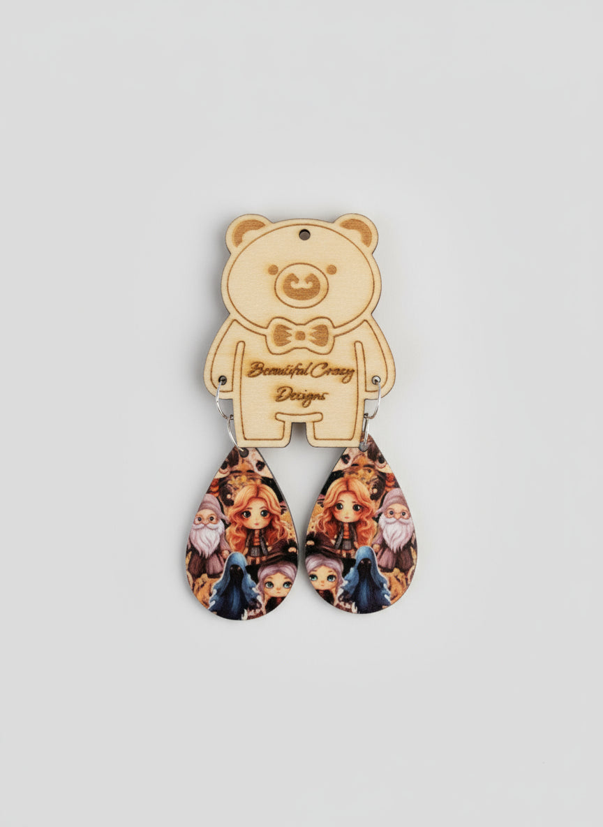 Teardrop-shaped earrings with character design on a black background
