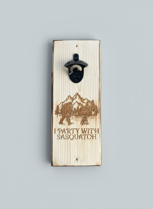 Wooden bottle opener with laser-engraved design and text on a dark background