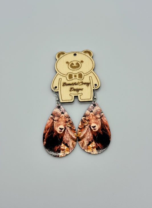 Bear-shaped earrings with teardrop design on a gray background