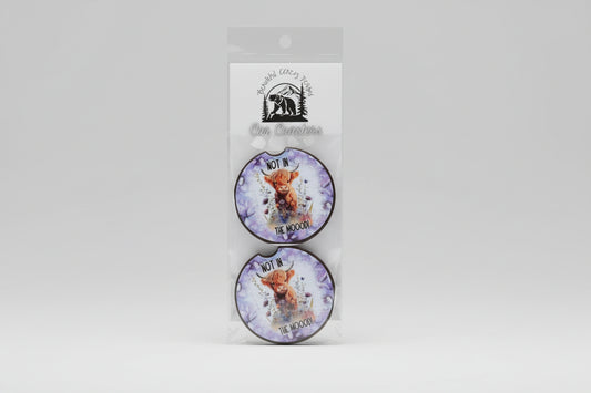 Two round coasters with a cow illustration and text 'Not in the moo!'.