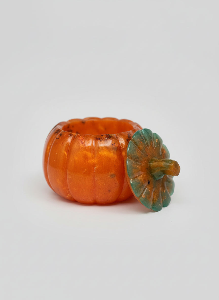 Resin pumpkin with green stem on a grey background