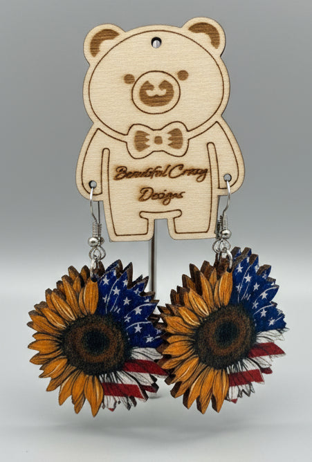 Wooden flower-shaped earrings with sunflower designs on a wooden background
