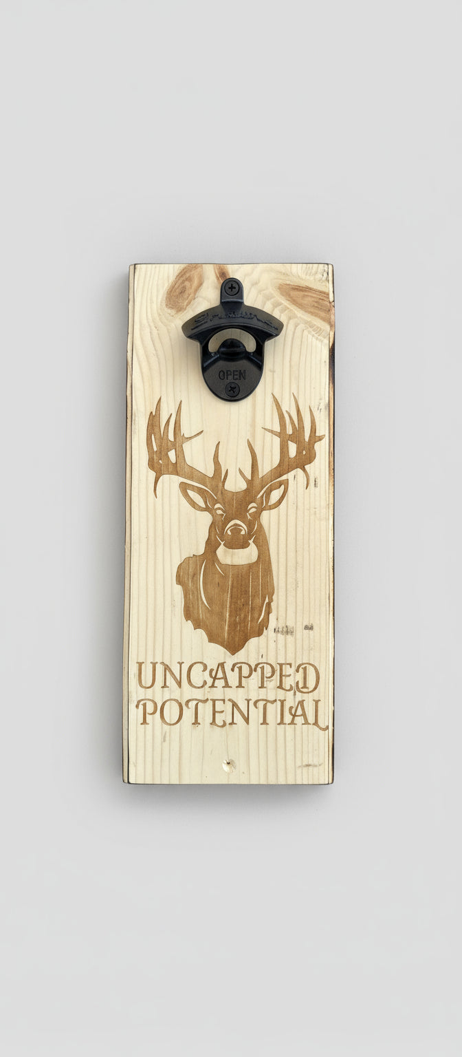 Wooden bottle opener with deer design and 'Uncapped Potential' text on a black background