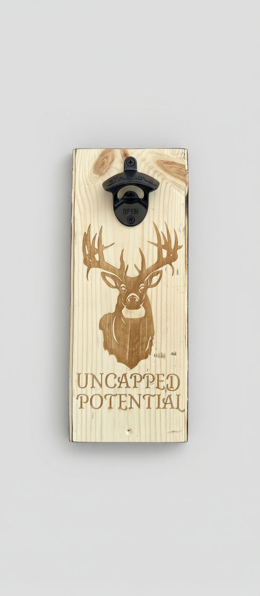 Wooden bottle opener with deer design and 'Uncapped Potential' text on a black background