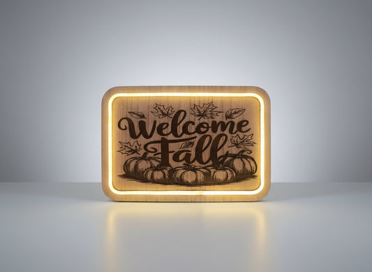 Wooden sign with 'Welcome Fall' engraving featuring pumpkins and leaves, illuminated from behind.