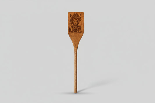 Wooden spatula with engraved design on a textured surface