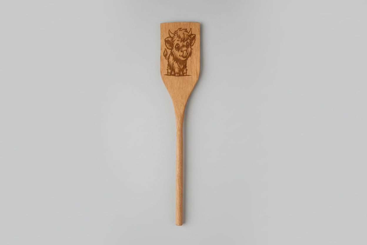 Wooden spatula with engraved design on a textured surface