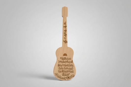 Wooden guitar-shaped paddle with engraved text on a wooden surface