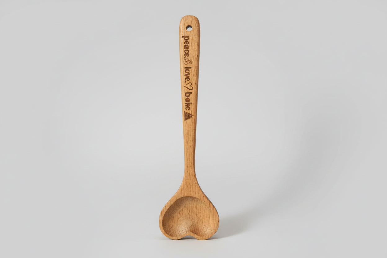 Wooden spoon with engraved text on a textured surface