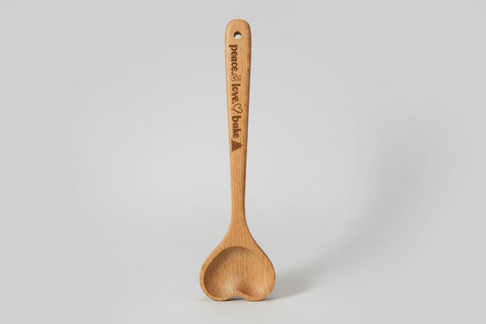 Wooden spoon with engraved text on a textured surface