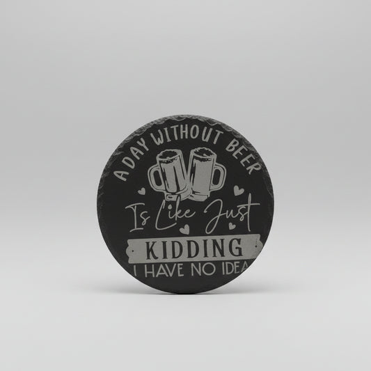 Round black coaster with white text and beer mugs design on a wooden surface.